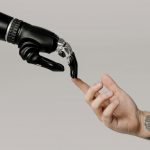 Doigt robotique touchant le doit humain lors d'une formation IA MyFormaBox